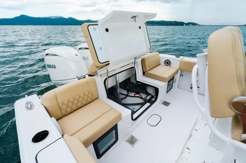 Slide: The Image of 2027 Sportsman Heritage 251 Center Console boat interior with tan seating and open storage. - 12