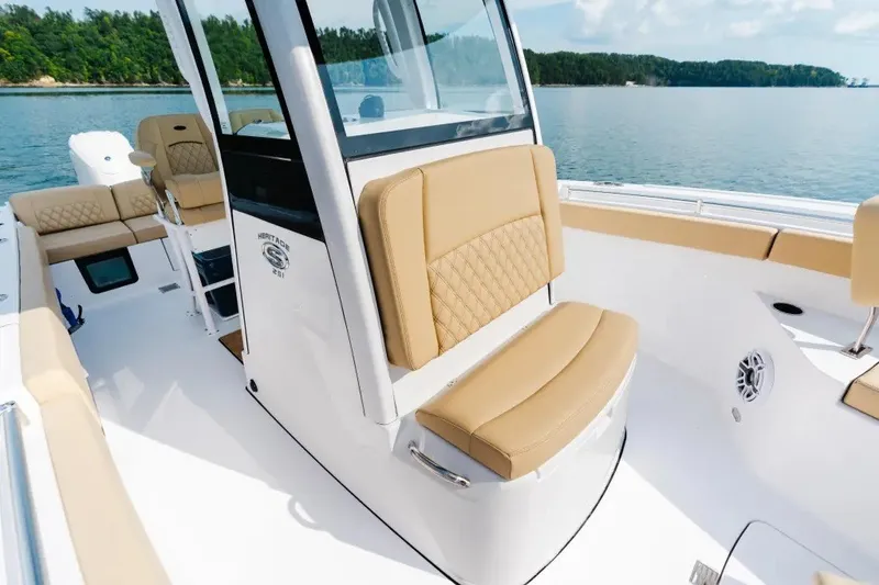 Slide: The Image of 2027 Sportsman Heritage 251 Center Console boat interior with tan seating on a sunny day. - 7