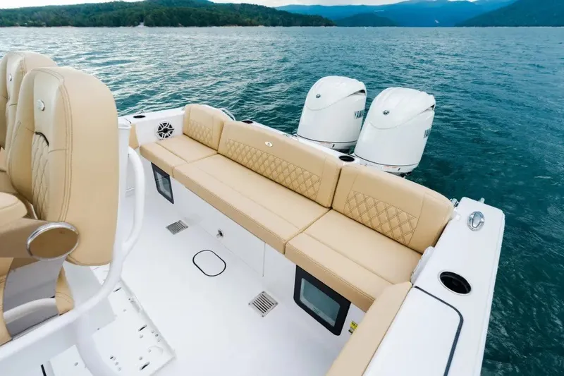 Slide: The Image of 2027 Sportsman Heritage 251 Center Console boat with beige seating on a lake. - 13