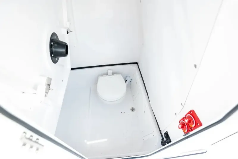 Slide: The Image of 2027 Sportsman Open 252 Center Console boat interior with compact marine toilet. - 10