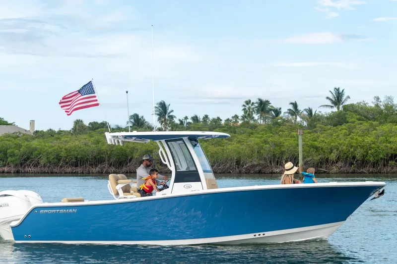 The Image of 2027 Sportsman Open 252 Center Console boat cruising with passengers, American flag flying. - 1
