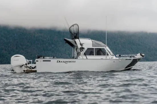 The Image of 2027 Duckworth 21 Discovery boat on a lake with forested hills in the background. - 1