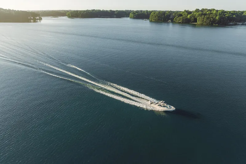 Slide: The Image of A Sea Ray SDX 270 Outboard boat speeds across a calm lake. - 6