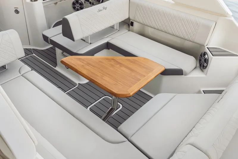 Slide: The Image of Interior of the Sea Ray SDX 270 Outboard with sleek white seating and a wooden table. - 16