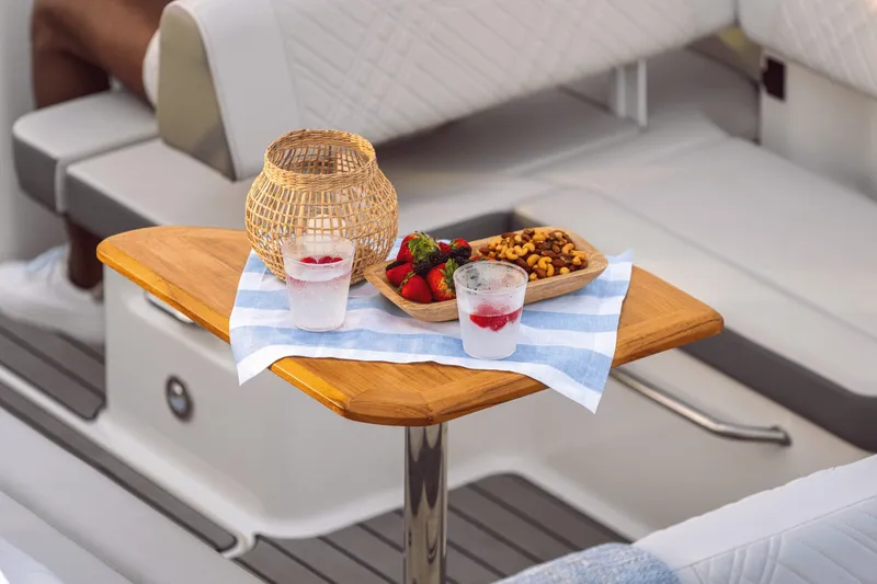 Slide: The Image of A stylish table on a boat with drinks, strawberries, and nuts on a blue cloth. - 18