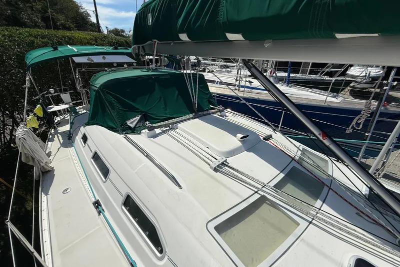 The Image of 2003 Beneteau Oceanis Clipper 393 sailboat with green canopy, docked at marina. - 0