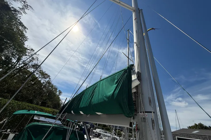 Slide: The Image of 2003 Beneteau Oceanis Clipper 393 sailboat with green sail cover under a sunny sky. - 7