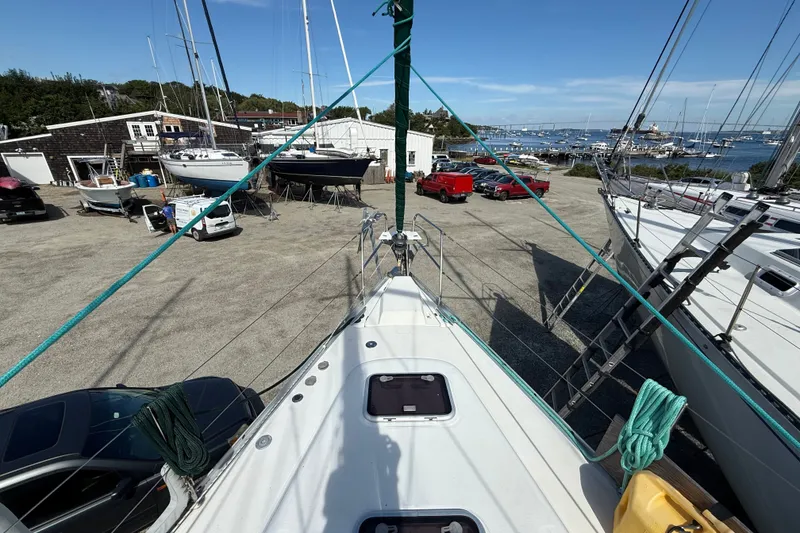 Slide: The Image of 2003 Beneteau Oceanis Clipper 393 sailboat on land, marina view in background. - 5