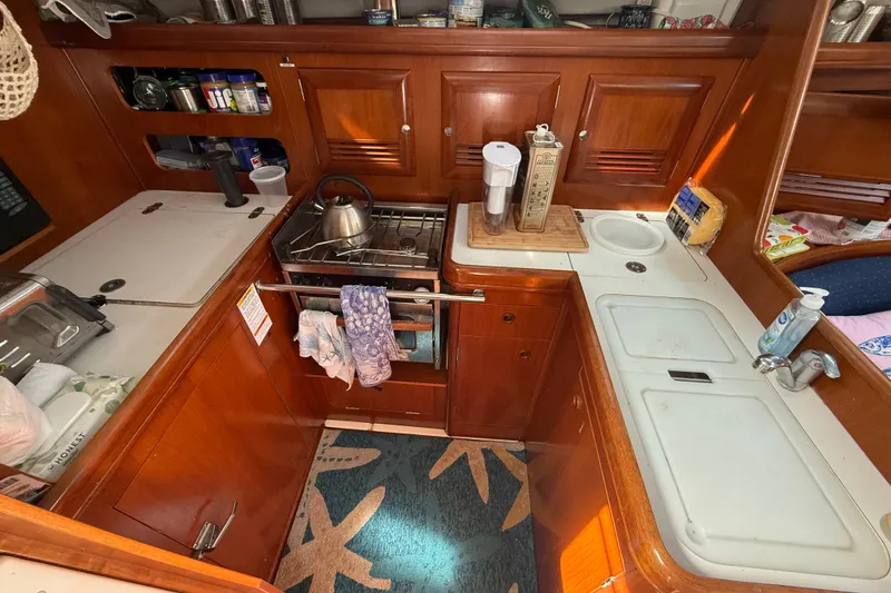 Slide: The Image of Galley kitchen in 2003 Beneteau Oceanis Clipper 393 sailboat with wooden cabinetry and appliances. - 17