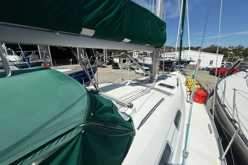 Slide: The Image of 2003 Beneteau Oceanis Clipper 393 sailboat with green covers docked at a marina. - 1