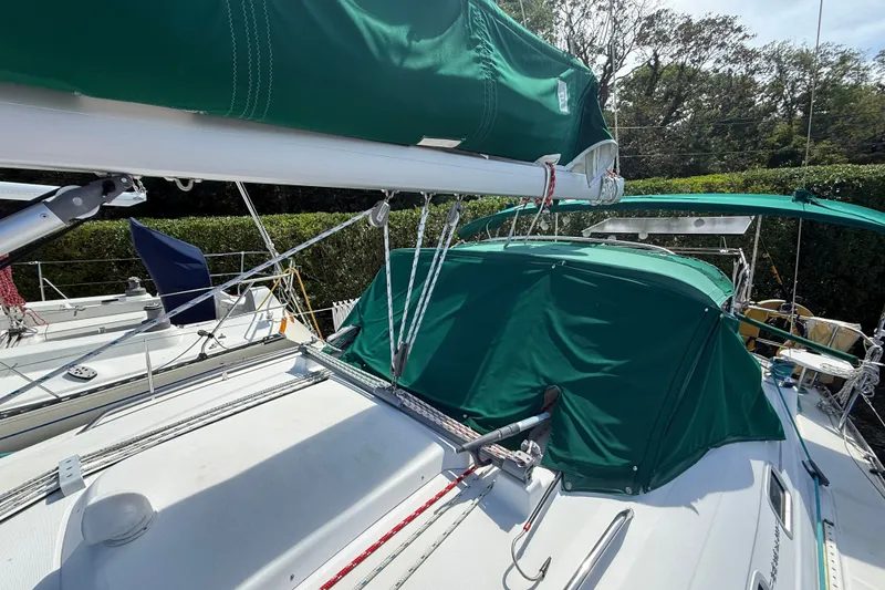 Slide: The Image of 2003 Beneteau Oceanis Clipper 393 sailboat with green covers and rigging details. - 8