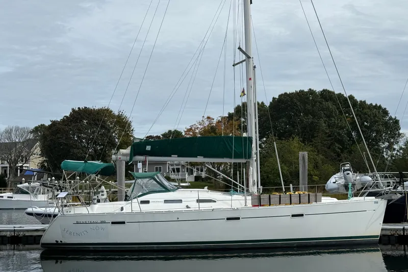 The Image of 2003 Beneteau Oceanis Clipper 393 sailboat docked at a marina, surrounded by trees. - 0