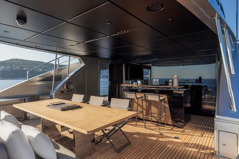 Slide: The Image of Luxurious 2026 Pershing GTX116 yacht interior with elegant dining and bar area, overlooking the sea. - 16