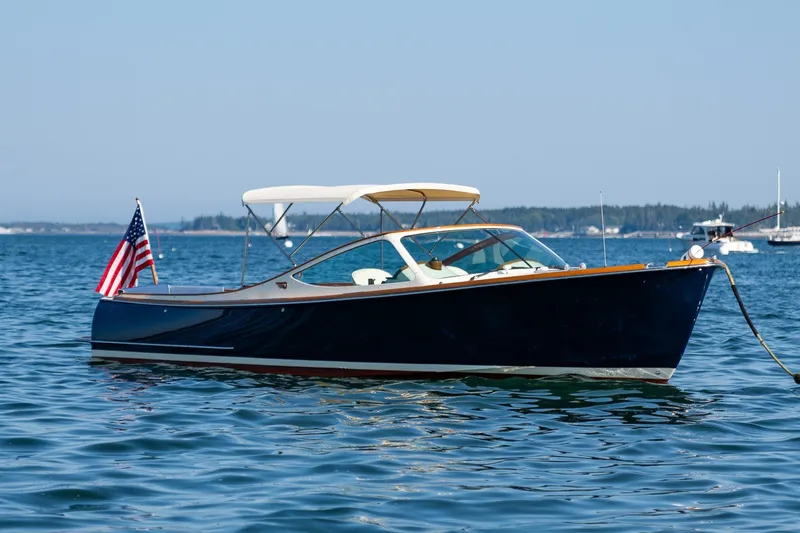 Slide: The Image of 2008 Hinckley Talaria 29R boat on calm water with American flag. - 4