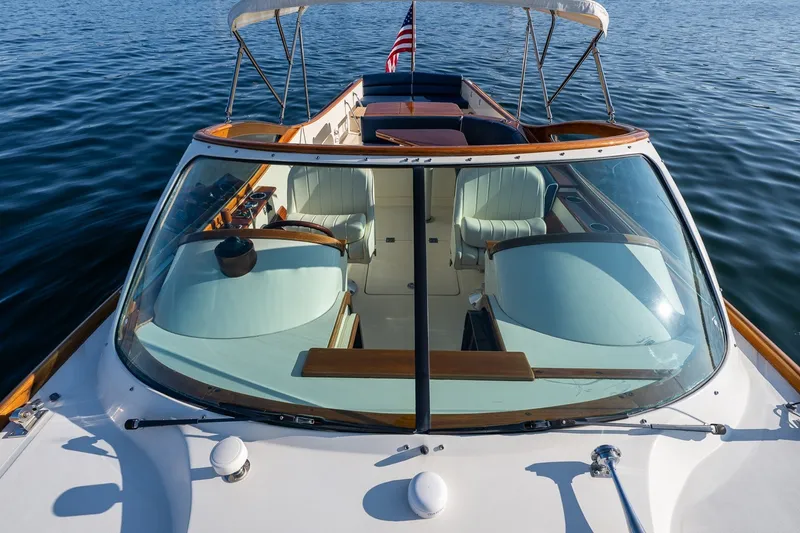 Slide: The Image of 2008 Hinckley Talaria 29R luxury boat with elegant seating and American flag on calm water. - 14
