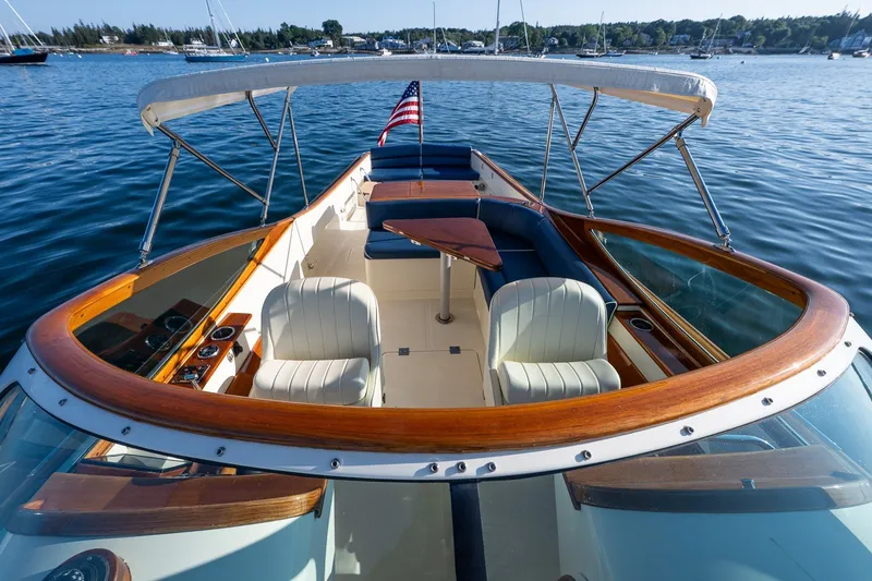 Slide: The Image of 2008 Hinckley Talaria 29R boat with elegant seating and wooden accents on calm water. - 15
