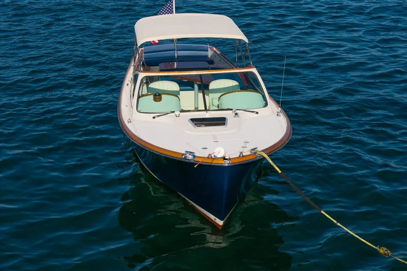 Slide: The Image of 2008 Hinckley Talaria 29R boat anchored on calm blue water. - 10