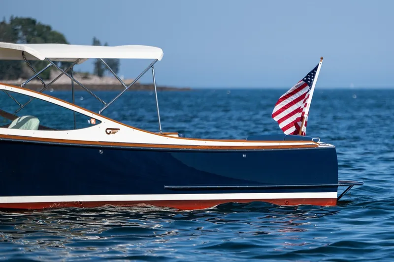 Slide: The Image of 2008 Hinckley Talaria 29R boat with American flag on calm blue water. - 7