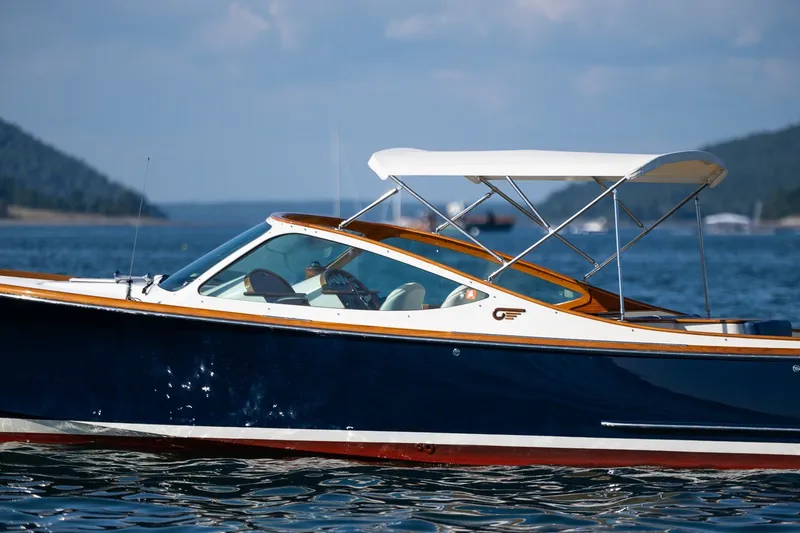 Slide: The Image of 2008 Hinckley Talaria 29R boat cruising on a scenic lake with hills in the background. - 6