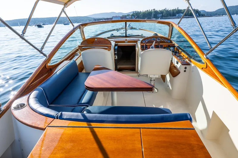 Slide: The Image of 2008 Hinckley Talaria 29R boat interior with elegant wood and blue seating on a sunny day. - 24