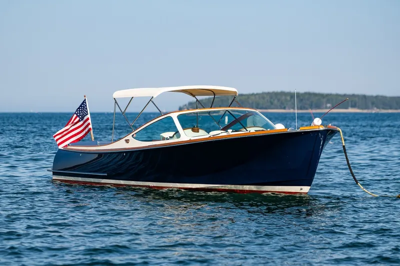 Slide: The Image of 2008 Hinckley Talaria 29R boat on calm water with American flag. - 33