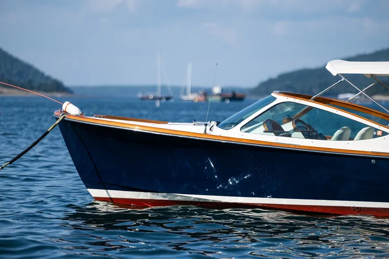 Slide: The Image of 2008 Hinckley Talaria 29R boat on calm water, scenic background. - 5