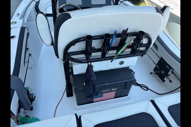 Slide: The Image of 2025 Tidewater 210 LXF boat interior with fishing rod holders and Yeti cooler. - 16