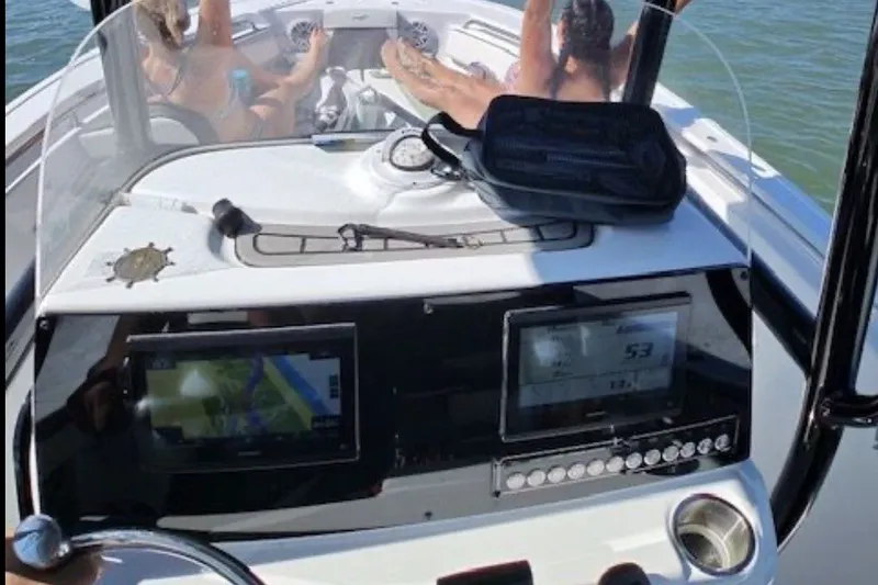 Slide: The Image of 2025 Tidewater 210 LXF boat dashboard with passengers relaxing in the background. - 10