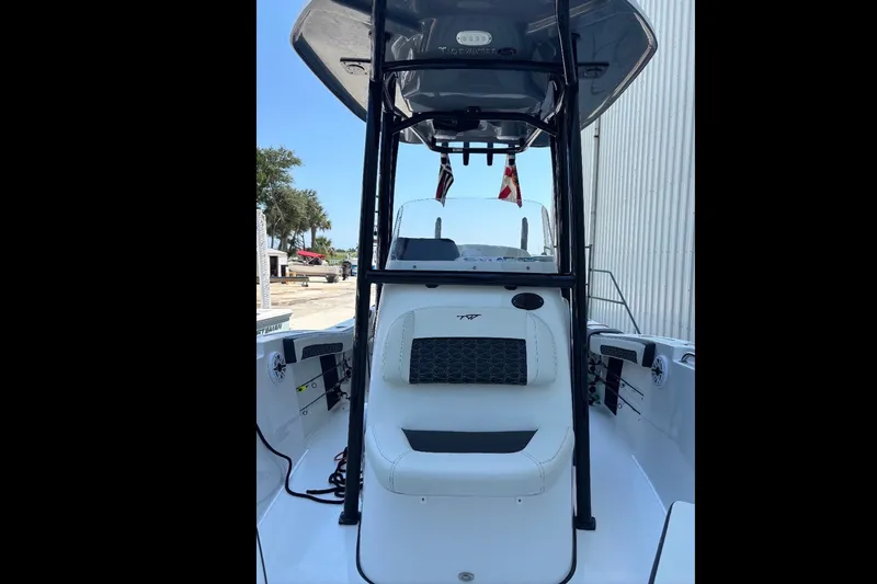 Slide: The Image of 2025 Tidewater 210 LXF boat interior with seating and console, docked outdoors. - 12