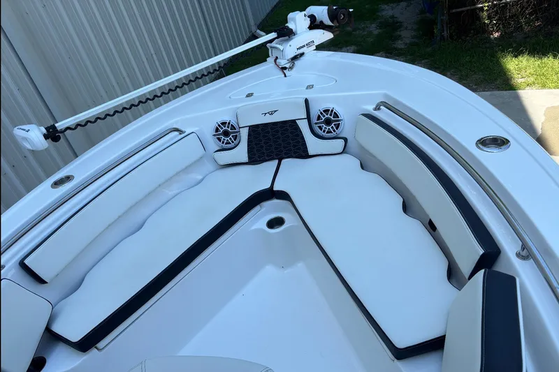 Slide: The Image of 2025 Tidewater 210 LXF boat interior with cushioned seating and Minn Kota trolling motor. - 11