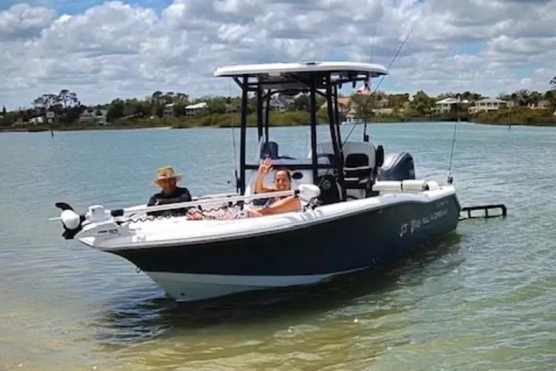 Slide: The Image of 2025 Tidewater 210 LXF boat on calm water with two people onboard, under a partly cloudy sky. - 7