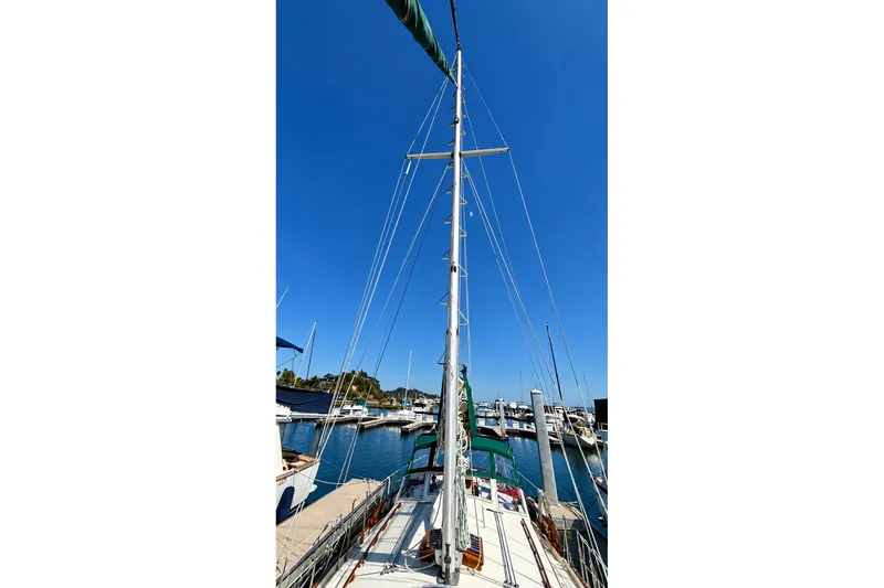 Slide: The Image of Sailboat Gozzard Cutter 36, 1988 model, docked in a marina under clear blue sky. - 14