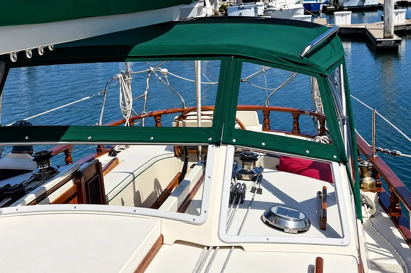 Slide: The Image of 1988 Gozzard Cutter 36 sailboat cockpit with green canopy and polished wood details. - 7