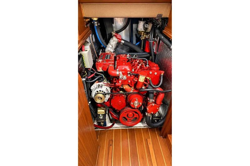 Slide: The Image of Engine compartment of a 1988 Gozzard Cutter 36 sailboat, featuring a red marine engine. - 28