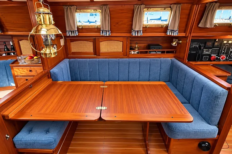 Slide: The Image of Interior of 1988 Gozzard Cutter 36 with wooden table and blue cushioned seating. - 18