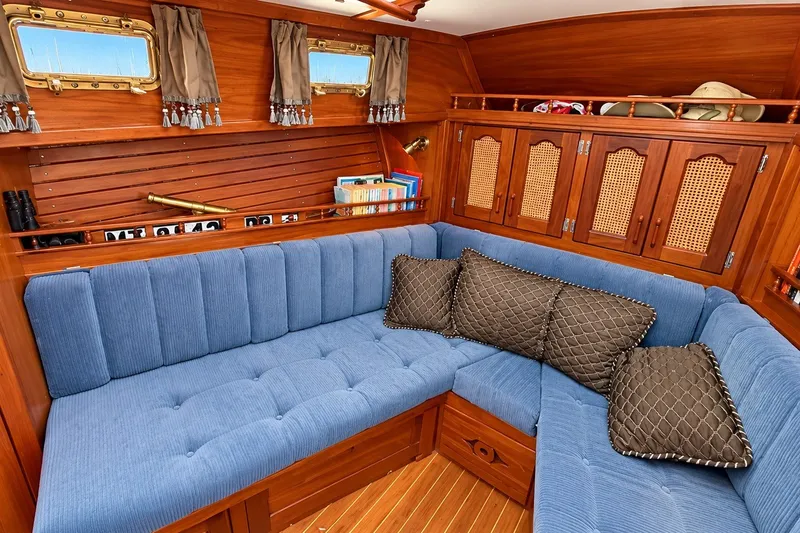 Slide: The Image of Cozy interior of 1988 Gozzard Cutter 36 with blue seating and wooden cabinetry. - 24
