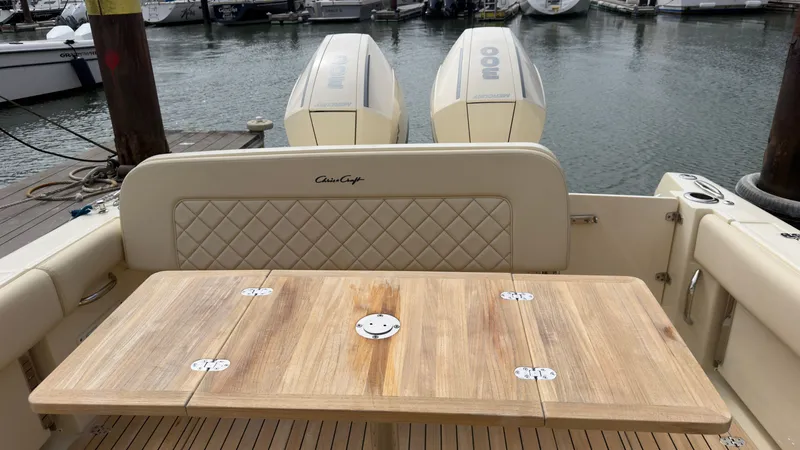 Slide: The Image of The image shows the stern of a 2022 Chris-Craft Calypso 30 boat with a wooden table. - 3