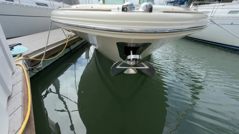 Slide: The Image of The 2022 Chris-Craft Calypso 30 is docked. The bow anchor is visible above the water. - 22