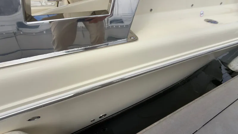 Slide: The Image of Close-up of a 2022 Chris-Craft Calypso 30 hull, docked at a marina. - 21