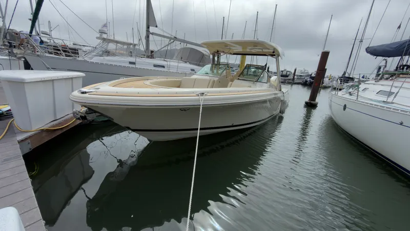 Slide: The Image of A 2022 Chris-Craft Calypso 30 docked, surrounded by other boats. - 19