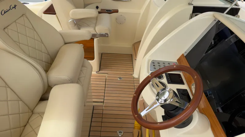 Slide: The Image of The image shows the cockpit of a 2022 Chris-Craft Calypso 30 boat with luxurious seating and a sleek steering wheel. - 12