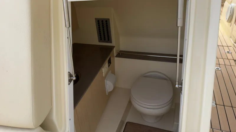Slide: The Image of The image shows a compact boat bathroom with a toilet and a sink. - 13