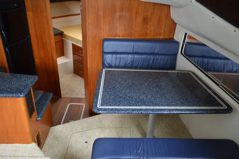 Slide: The Image of Interior of 2000 Carver 356 Aft Cabin Motor Yacht with dining area and wood accents. - 31