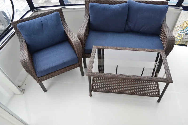 Slide: The Image of Outdoor seating on Carver 356 Aft Cabin Motor Yacht, featuring wicker furniture with blue cushions. - 16