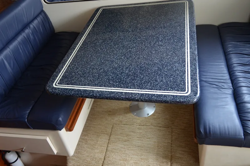 Slide: The Image of Interior of 2000 Carver 356 Aft Cabin Motor Yacht with blue seating and speckled table. - 30