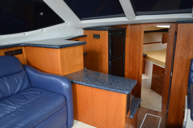 Slide: The Image of Interior of 2000 Carver 356 Aft Cabin Motor Yacht with blue seating and wood cabinetry. - 33