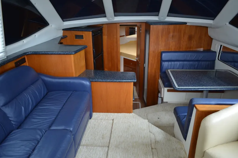 Slide: The Image of Interior of 2000 Carver 356 Aft Cabin Motor Yacht with blue seating and wood accents. - 26