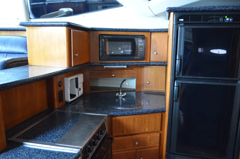 Slide: The Image of 2000 Carver 356 Aft Cabin Motor Yacht kitchen with microwave, sink, and refrigerator. - 34