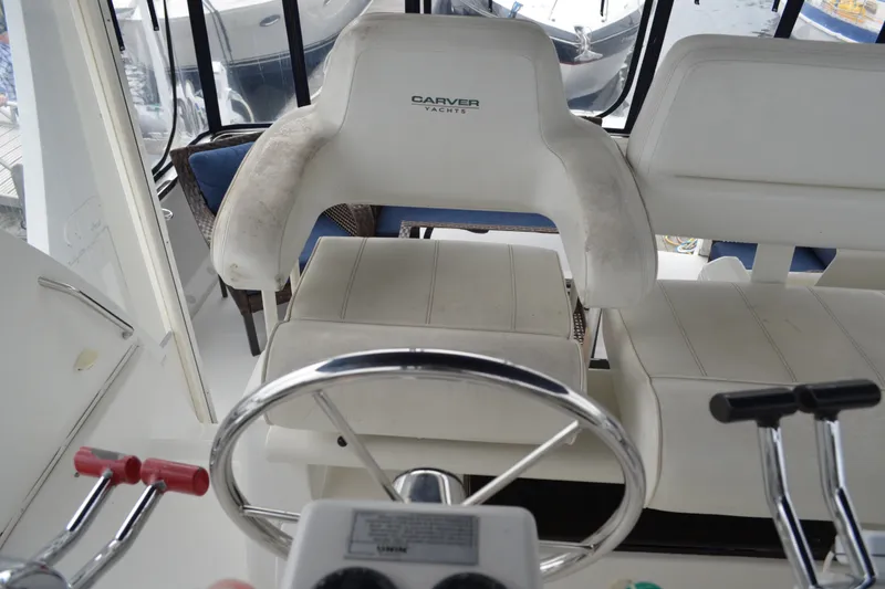 Slide: The Image of Steering area of 2000 Carver 356 Aft Cabin Motor Yacht with white seating. - 20