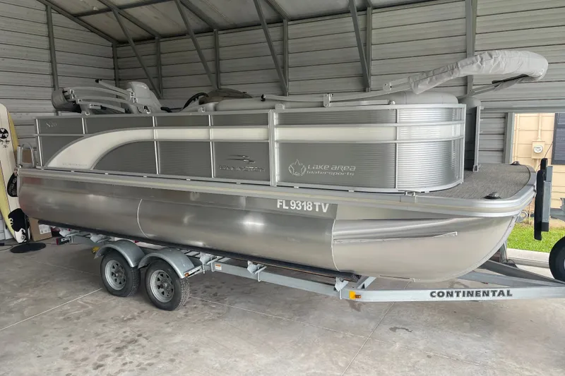 The Image of 2023 Bennington 20 SS pontoon boat on trailer in covered storage. - 1